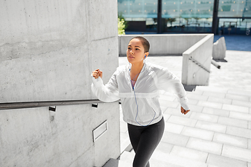 Image showing african american woman running upstairs outdoors