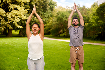 Image showing happy people doing yoga at summer park