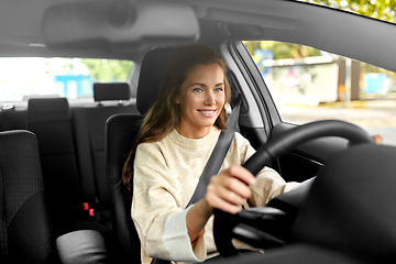 Image showing smiling woman or female driver driving car in city