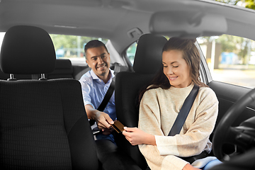 Image showing female car driver takes credit card from passenger