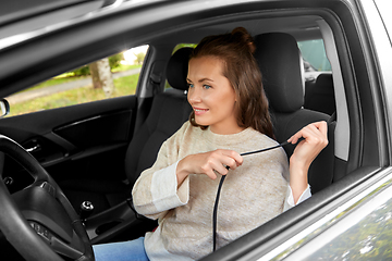 Image showing woman or female driver fastening seat belt in car