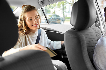 Image showing female passenger passing credit card to car driver