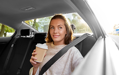 Image showing smiling woman or passenger drinking coffee in car