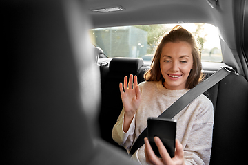 Image showing happy woman in car having video call on smartphone