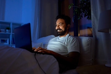 Image showing indian man with laptop in bed at home at night