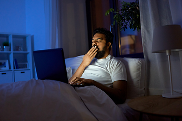 Image showing indian man with laptop in bed at home at night