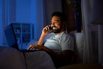 Image showing indian man with laptop calling on phone at night