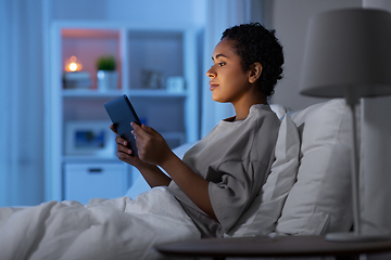 Image showing woman with tablet pc in bed at home at night