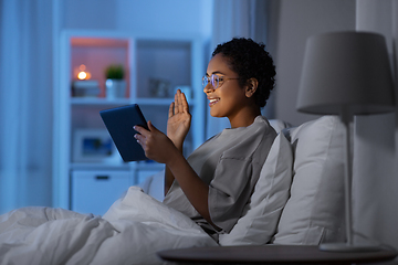 Image showing woman with tablet pc in bed has video call at night