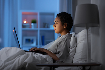 Image showing woman with laptop in bed at home at night