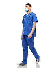 Image showing male doctor in blue uniform and mask walking