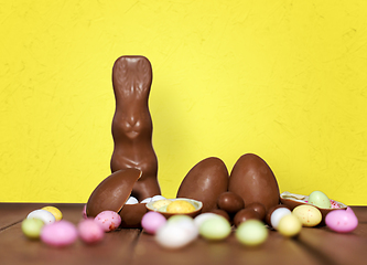 Image showing chocolate eggs, easter bunny and candies on wood