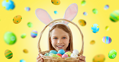 Image showing happy girl with colored easter eggs on yellow