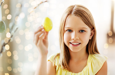 Image showing girl decorating willow by easter eggs at home