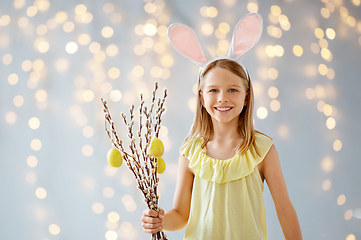 Image showing smiling girl with willow decorated by easter eggs
