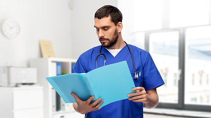 Image showing male doctor reading medical report in folder