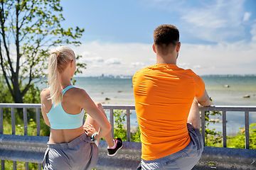 Image showing young sporty couple stretching legs