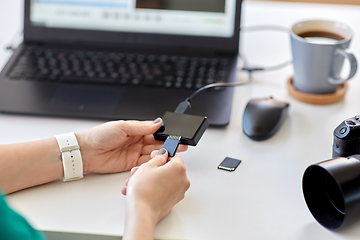 Image showing woman with sd card reader and laptop at office