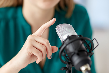 Image showing woman with microphone recording podcast at studio