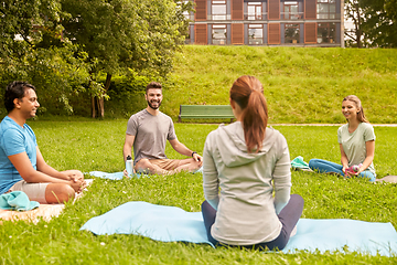 Image showing group of people sitting on yoga mats at park