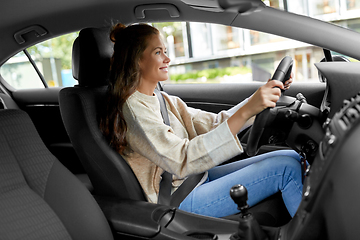 Image showing smiling woman or female driver driving car in city