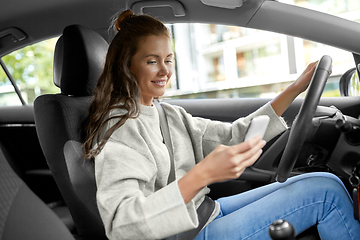 Image showing smiling woman or female driver driving car in city