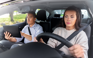 Image showing woman and driving school instructor in car