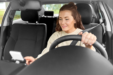 Image showing smiling woman or female driver driving car in city