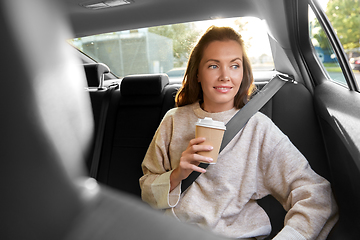 Image showing smiling woman or passenger drinking coffee in car