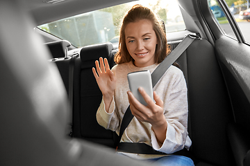 Image showing happy woman in car having video call on smartphone