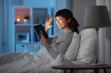 Image showing woman with tablet pc in bed has video call at night