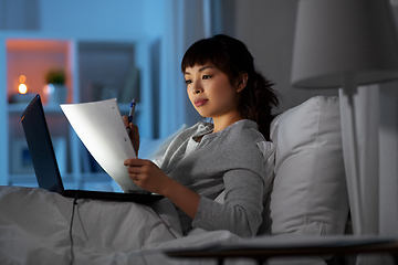 Image showing woman with laptop working in bed at night