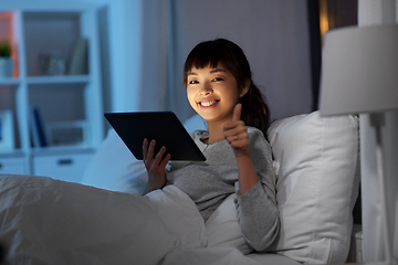 Image showing asian woman with tablet pc in bed at home at night