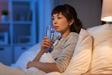 Image showing asian woman drinking water at night in bed