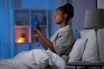 Image showing woman with tablet pc in bed at home at night