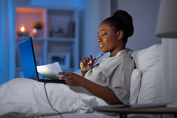 Image showing woman with laptop working in bed at night