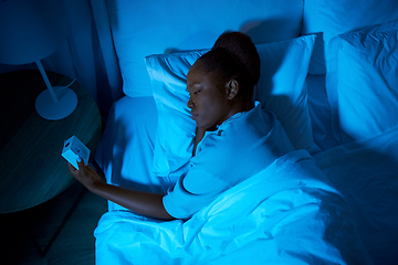 Image showing woman awaking because of alarm clock at night