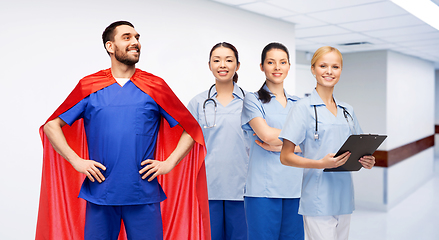 Image showing male doctor in superhero cape and nurses at clinic