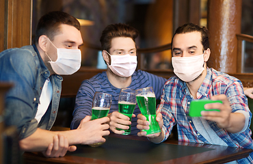 Image showing friends with green beer taking selfieat pub