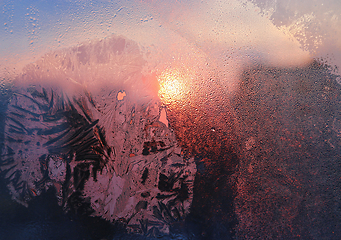 Image showing Ice patterns, water drops and sunlight on a window glass 