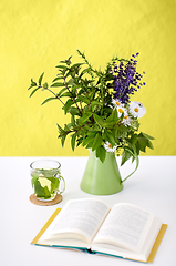 Image showing herbal tea, book and flowers in jug on table