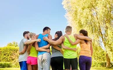 Image showing group of happy sporty friends hugging outdoors