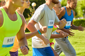 Image showing happ young sportsmen racing wit badge numbers