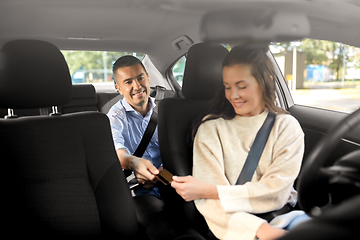 Image showing female car driver takes credit card from passenger