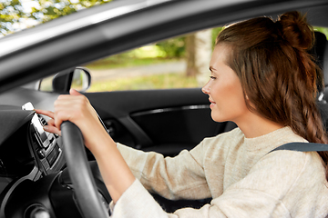 Image showing smiling woman or female driver driving car in city