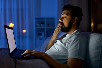 Image showing indian man with laptop in bed at home at night