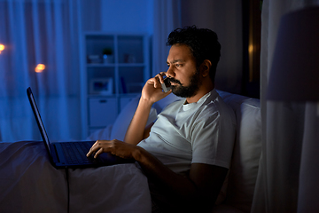 Image showing indian man with laptop calling on phone at night