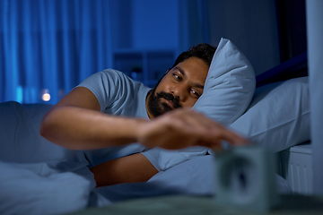 Image showing indian man awaking because of alarm clock at night