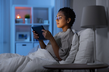 Image showing woman with tablet pc in bed at home at night