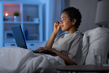 Image showing woman with laptop in bed at home at night